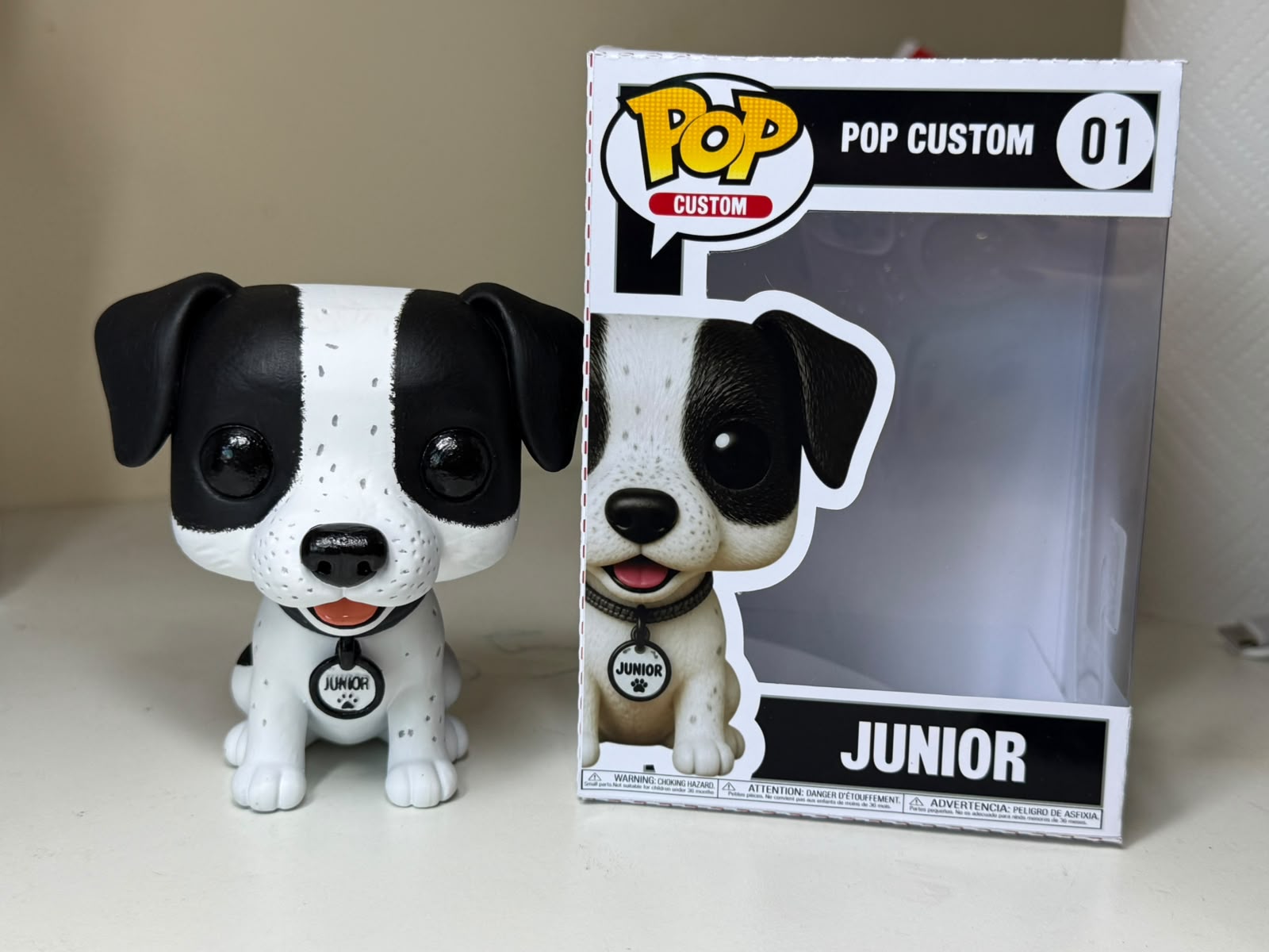 Miniatura GAEVA do pet Junior, peça pintada à mão ao lado da caixa colecionável