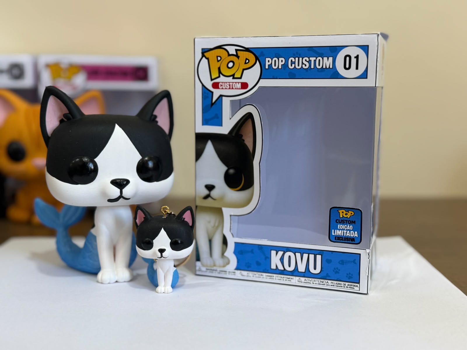 Miniatura GAEVA do pet Kovu, peça pintada à mão ao lado da caixa colecionável
